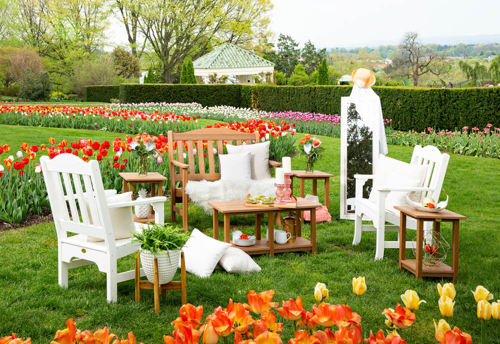 Poly outdoor furniture on lawn by blooming tulips