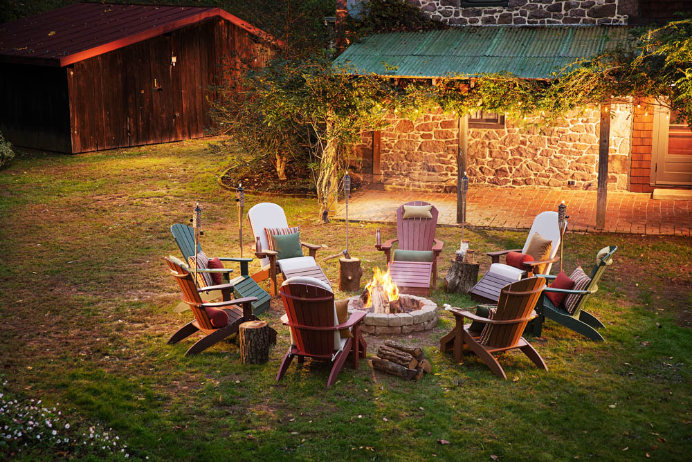 Adirondack chairs around a campfire