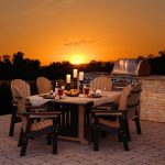 Amish crafted poly outdoor dining furniture on hardscape patio at sunset.