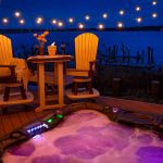 Amish crafted bar height chairs and conversation table on deck beside hot tub at dusk
