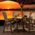Outdoor furniture under a pergola at sunset
