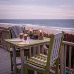 Amish crafted poly chairs and small table on an oceanfront deck.
