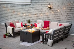 Poly outdoor furniture around a fire pit on a hardscape patio.