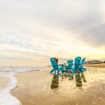 Amish crafted poly outdoor furniture - Aruba blue Adirondack chairs on beach at sunset