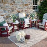poly chairs on patio with stone home background
