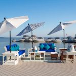 Amish handcrafted poly patio furniture on boardwalk by boat dock.
