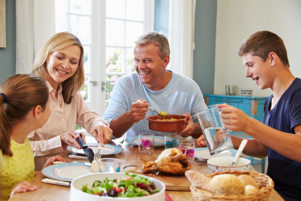 Family sitting around a dining table eating dinner